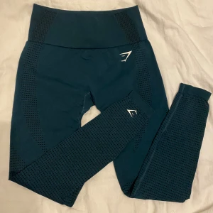 Vital seamless leggings från Gymshark - Snygga mörkgröna leggings från Gymshark med hög midja. Stretchigt material som sitter tight och bekvämt, perfekt för gymmet eller andra träningspass. Diskret logga i vitt på benet och höften. Endast använda ett fåtal ggr! Ordinarie pris 549kr✨
