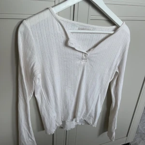 Tröja med knappar  - Långärmad tröja med knappar längst fram från lager. Mycket fint skick, knappt använd. Offwhite beige färg aktig.