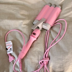 Rosa vågtång med digital display - Snygg rosa vågtång för håret med digital temperaturdisplay och justerbara värmeinställningar. Ergonomiskt handtag och säkerhetsfunktion. Använd några få gånger och är knappt sliten. Perfekt för att skapa snygga vågor snabbt och enkelt.