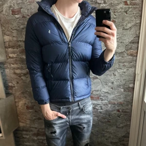 Ralph lauren dunjacka - Säljer denna feta Ralph lauren jackan i bra skick den är lite revig och smutsig under högra ärmen och hängslet har lossnat men det är inget som märks!⭐️Storlek : 14-16 men passar XS, modellen e 185 men jackan e ca 15-20cm för kort!🤝Den passar mellan 160-170!👍 Hör gärna av er om ni har funderingar!🙌