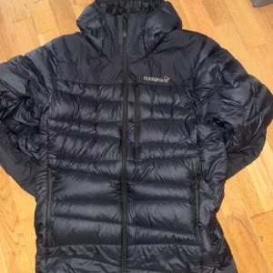 Svart höstjacka från Norrøna med huva - Säljer en svart höstjacka från Norrøna med huva och snygga quiltade paneler. Jackan har dragkedja framtill, två sidofickor med dragkedja och en bröstficka. Perfekt för kalla dagar och har en clean, sportig look. Nypris är 4000 storlek S men passar M jag själv har M och den passar mig 