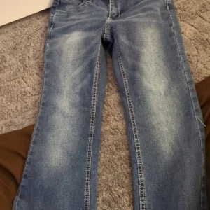 Blå jeansbyxor från Shein, stl S - Snygga blå jeansbyxor från Shein i storlek S. Klassisk femficksmodell med ljusa slitningar framtill och raka ben. Jeansen har normal passform och är tillverkade i jeansmaterial med tydliga sömmar längs benen. Perfekta för en chill och trendig look. 