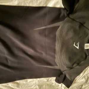 Gymshark onyx v5 GR0/SVART M - Onyx V5 är den femte generationen i Gymshark’s exklusiva “Onyx”-kollektion – en träningstopp/slim fit-serie med hög kompression och designad för att framhäva fysiken.  ￼ Kollektionen är extremt begränsad och har fått stor hype bland tränings- och gymkläder-entusiaster.  ￼