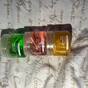 Spascriptions gel face mask trio - Tre gel face masks från Spascriptions i burkar om 50 ml. En grön med gurka, en rosa med ros och en guldig med glitter. Perfekt för dig som vill testa olika ansiktsmasker med fräscha dofter och snygga färger. Burkarna är genomskinliga plast med vita lock.