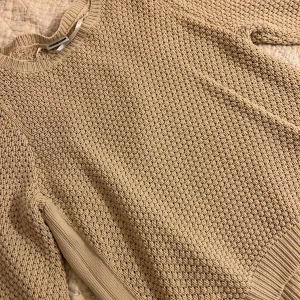 Beige stickad tröja från Noisy May - Säljer en beige stickad tröja från Noisy May med grov struktur och rund hals. Tröjan har långa ärmar och ribbade muddar vid ärmslut och nederkant. Perfekt för dig som gillar en chill och enkel stil. 