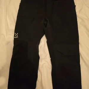 Haglöfs friluftsbyxor  - Säljer nu ett par svarta friluftsbyxor från märket Haglöfs. Perfekta för utomhusaktiviteter och har en stilren look med diskret Haglöfs-logga på benet🚀