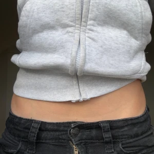 Svarta bootcut jeans med låg midja - Säljer ett par svarta jeans med låg midja och bootcut-ben. Jeansen har klassiska fickor fram och bak, samt knapp- och dragkedjestängning. Snygg passform som sitter tajt upptill och släpper ut vid bensluten. Perfekta till sneakers eller boots.