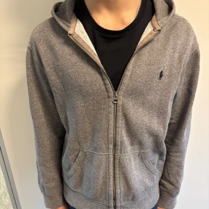 Grå zip hoodie från Polo Ralph Lauren - Grå Ralph Lauren zip hoodie Storlek L men passar även passa M Skick: 8/10✅ Nypris cirka 1800kr✅ Hör av er vid fler frågor eller funderingar