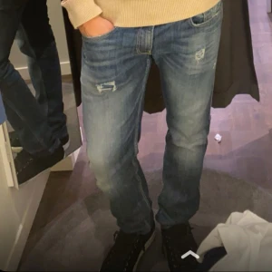 Blå jeans med slitningar - Snygga blå jeans med slitna detaljer och klassisk femficksdesign. Jeansen har en rak passform och är tillverkade i jeansmaterial. Perfekta för dig som gillar en avslappnad och cool stil.