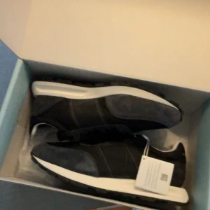 Svarta sneakers Philippe Model Paris - Philippe Model Paris. Skorna har en kombination av mocka och syntetmaterial, svarta snören och en vit mellansula. Klassisk design med diskret logga på plösen och mönstrad yttersula.                 Priset går att diskuteras. Hör av er vid frågor.