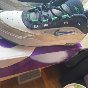 Nike SB Air Zoom Ishod sneakers - Nike SB Air Zoom Ishod sneakers i vitt, beige och marinblått med gröna detaljer. Skorna har mesh och mocka-paneler, gröna snörhål och broderad Nike SB-logga på hälen. Swoosh-logga i blått och grönt på sidan. Perfekta för dig som gillar streetwear och skate.