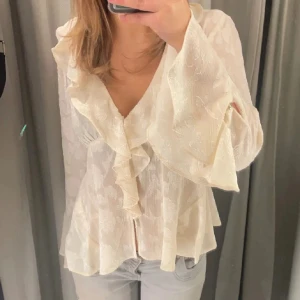 Vit blus med volang och v-ringning - Säljer en söt vit blus med v-ringning och volangdetaljer framtill. Priset kan diskuteras vid snabb affär😊