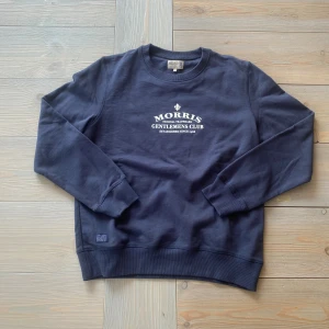 Marinblå Morris-tröja – stilren och somrig basic 🌊 - Klassisk Morris-tröja i marinblått, storlek M (märkt L men passar M bäst). Mjuk bomull och snygg passform – en perfekt övertröja svala sommarkvällar. ✅ Inga defekter 💸 Kampanjpris – endast 299 kr 📦 Fri frakt hela veckan! 