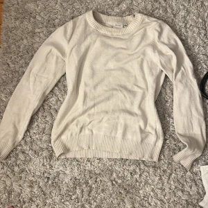 Vit stickad tröja från Vila XS - Enkel och stilren vit stickad tröja från Vila i storlek XS. Tröjan har rund halsringning, ribbade muddar vid ärmslut och nederkant samt lång ärm. Perfekt att matcha med jeans eller kjol för en clean look.säljer pga att den inte längre kommer till användning💞💞