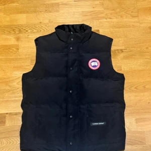 Svart Canada Goose väst - Svart Canada Goose väst. Är i bästa skicket med prislapp och helt oanvänd. Västen är varm och jätte skön på.