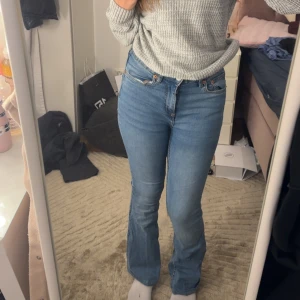 Bootcut jeans från 157, ljusblå - Snygga ljusblå bootcut jeans från 157 med klassisk femficksdesign och knappgylf. Jeansen har en högre midja och är tillverkade i mjukt denimtyg med lite stretch för skön passform. Perfekt för dig som gillar retrovibbar och vill ha ett avslappnat men trendigt uttryck. Priset kan diskuteras 