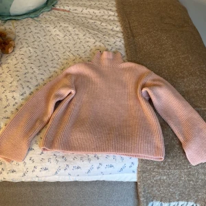 Rosa ribbad polotröja från H&M - Mysig ljusrosa polotröja från H&M i ribbstickad design. Tröjan har lång ärm och hög krage. Näst intill ny, super fint skick💕