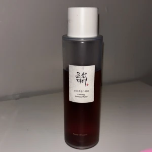 Beauty of Joseon Ginseng Essence Water - Ginseng Essence Water från Beauty of Joseon i en stilren, genomskinlig plastflaska med vit kork. Innehållet är brunt och formulan är lättflytande, perfekt för att återfukta och fräscha upp huden. K-beauty favorit med naturliga ingredienser.