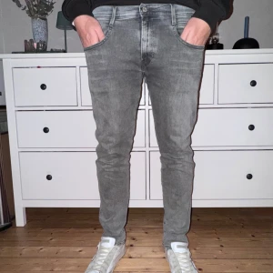 Replay Anbass grå jeans, stl 34/30 - Snygga grå jeans från Replay i modellen Anbass Hyperflex. Jeansen har klassisk femficksdesign, slim passform och diskreta sömmar på bakfickorna. Materialet är mjukt denim som sitter skönt och passar perfekt till en avslappnad stil. Lite använda pga snabbt urväxta. 