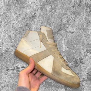 Vita maison margiela gats - Vita höga margiela gats I okej skick. Litet hål som inte syns med vita strumpor och lite flagande färg på båda hälarna. Utöver det bra skick. Äkta, bara skorna ingår. Storlek 41 men passar 42 lika bra. Kom gärna med frågor😊