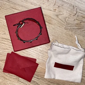 ÄKTA Valentino Armband Röd Guld Nitar - Finns en liten skada som jag åtgärdat vid slutet av armbandet där det lossnade. Synns inte vid användning och svårt att lägga märke till. Nypris typ 3000.