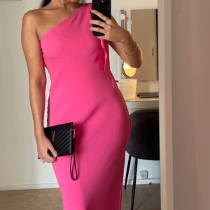 Rosa one shoulder långklänning  - Säljer en snygg långklänning i rosa med one shoulder-design med knyt vid ena axeln. Klänningen har också slits på varsin sida. Klänningen är från Mango i storlek XS. Passar också om man har S i storlek!!
