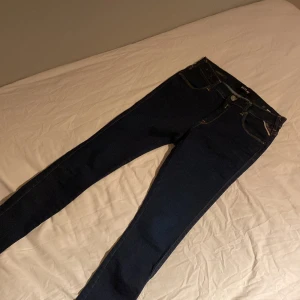 Mörkblå Replay jeans slim fit - Snygga mörkblå jeans från Replay i modellen slim fit. Klassisk femficksdesign, smala ben och normal midja. Jeansen är tillverkade i stretchigt bomullsmaterial för en bekväm passform. Perfekta för dig som gillar en stilren och enkel look.