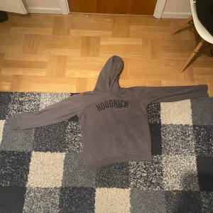 Grå hoodie från Hoodrich XL I barn  - Säljer en grå hoodie från Hoodrich i storlek XL BARN. Tröjan har tryckt logga på bröstet och textdetaljer på ryggen. Klassisk huva och magficka framtill, perfekt för streetwear-stilen. Materialet är mjukt och känns skönt mot huden. Den här tröjan är i Bra skick, den enda saken är det att den har som en rivmärke på ryggen men det syns knappt. En till sak är att den är liten i storlek, jag skulle säga att den passar längden 155/160 CM. 