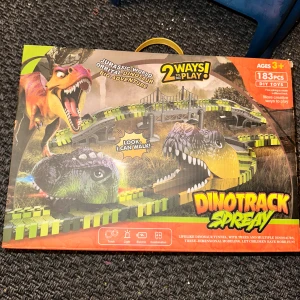 Dinotrack Spray DIY Dinosaur Racing Track Dinosauriebana med 183 delar - Dinotrack Spray är ett elektriskt dinosaurierace med 183 delar, flexibla banor och realistiska dinosaurier. Passar barn från 3 år. Lätt att montera, med ljus och rörelsefunktion. Kartongen har mindre slitage men innehållet är komplett och i gott skick.Rolig dinosauriebana med många tillbehör. Innehåller 183 delar och kan byggas på två olika sätt. Perfekt för barn från 3 år och uppåt. Kräver 1,5V AA-batterier (ingår ej).