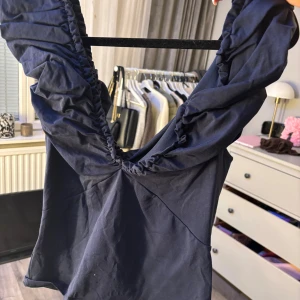 Mörkblå topp med volangaxlar - Supersnygg mörkblå topp med markerad v-ringning och volangdetaljer vid axlarna. Skriv för fler bilder💘