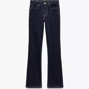 Mörkblå bootcut jeans - Snygga mörkblå jeans med bootcut passform och klassisk femficksdesign. Jeansen har låg midja och är tillverkade i ett stretchigt denimtyg som sitter bekvämt. Perfekta för dig som gillar en retro vibe och vill ha ett par jeans som framhäver benen.