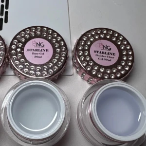 Starline Base Gel och Builder Gel 30ml/160kr  båda - Två burkar Starline gel från NG Nails, en Base Gel och en Builder Clear Gel, båda på 30ml. Burkarna är rosa med glittriga stenar på locket och har en lyxig look. Perfekt för dig som älskar nagelvård och vill ha snygga förpackningar på sminkbordet.