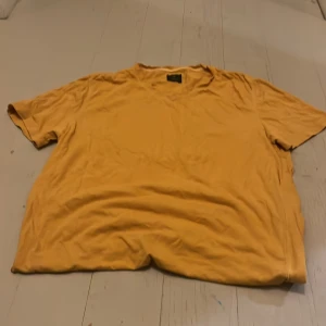 Gul t-shirt från 157 Premium Basic - Snygg gul t-shirt från 157 Premium Basic i storlek small. Modellen är klassisk med rund hals och korta ärmar, perfekt för dig som gillar enkel och stilren design. Materialet är mjukt och skönt bomull som känns bra mot huden.