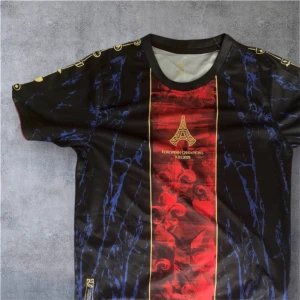 Svart och röd fotbollströja Paris 2025 - Snygg fotbollströja med svart bas, blå mönsterdetaljer och en röd vertikal panel i mitten med guldtryck och Eiffeltornet. Texten 'European Champions 31.05.2025' på bröstet. Rund halsringning och korta ärmar. Perfekt för dig som gillar unik design.