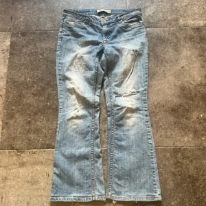 Lågmidjade bootcut jeans med slitningar - Säljer dessa skit snygga jeans med hål! Vet inte vilket märke det är men det står Jsfn Denim, strl 31/32. Passar någon med: Innerbenslängd - 71 cm Midjemått - 39 cm