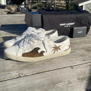 Limted Edition Saint Laurent vita sneakers Sea, Sex and Sun - Limted edition sneakers från Yves Saint Laurent.  Box och kort följer med, dustbag har tyvärr tappats bort. Storlek 39 men passar mig som har 40. Skorna säljs inte i butik sen långt tillbaka så de är mycket sällsynta i detta skick.        Nypris ≈9000kr. VÅGA STÄLLA FRÅGOR OCH BUDA!!!