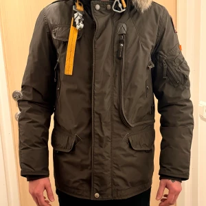 Parajumpers jacka storlek S - Säljer en Parajumpers dunjacka i färgen olive green från masterpiece serien, med päls på huvan och detaljer som gul rem och flera fickor. Jackan har dragkedja, knappar och är långärmad. Insidan är quiltad och fodrad för extra värme. Perfekt inför vintern. Är köpt för 10 000 kr och är i bra skick! 