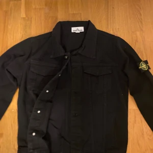 Svart overshirt från Stone Island - Svart overshirt i jeansmaterial från Stone Island. Cond:9:10. Säljer då jag ej använder längre eftersom det ej är min stil. Passar perfekt nu till vintern. Storlek  M men mindre i storleken