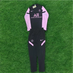 PSG långärmad träningsset Nike - Paris Saint-Germain träningsset från Nike med långärmad tröja och byxor i svart och ljusrosa. Tröjan har PSG-logga, sponsortryck och mönstrade ärmar. Byxorna har PSG-emblem och rosa detaljer. Materialet är lätt och andas, perfekt för fotbollsträning.