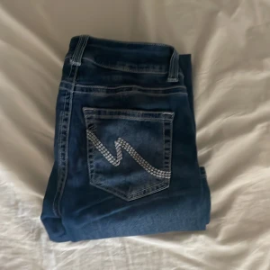 NELLY Jeans - Säljer ett par blåa, low waist bootcut jeans från Nelly i storlek 32. Är använda några gånger men är i mycket bra skick💕