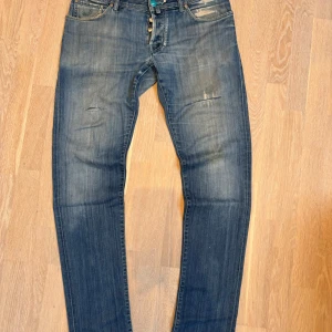 Jacob Cohen jeans med en otrolig tvätt samt feta slitningar - As goa Jacob cohen jeans med en riktig fet ljusblå tvätt samt otroliga slitningar. Dessa har använts mycket och har därav behövts lagas i skrevet(se sista bilden), kan behövas göra snart igen! Men har dock en del kvar att ge! Size W36 sitter true to size eller lite mindre.