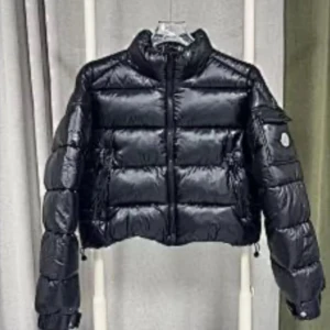 Svart pufferjacka från Moncler - Säljer en svart pufferjacka från Moncler med klassisk logga på ärmen. Jackan har hög krage, dragkedja framtill och praktiska fickor med lock. Den är lätt glansig och har en boxig, lite croppad passform som är riktigt trendig just nu.