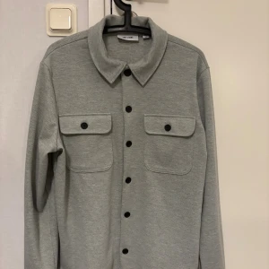 Grå overshirt  - Säljer en grå overshirt i storlek M från märket only & sons, den har bara använts 1 gång och det finns inga tecken på användning. Köpte den för 500 säljer för 300.