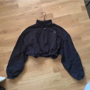 Svart croppad half zip hoodie Oner Active - Svart croppad tröja med half zip och hög krage från Oner Active. Tröjan har långa ärmar och resår vid ärmslut och midja. 