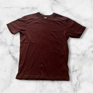 Brun Uniqlo U t-shirt i bomull - Säljer en basic brun t-shirt från Uniqlo U i storlek S. T-shirten är tillverkad i 100% bomull, har rund halsringning och klassisk passform. Perfekt för en clean och enkel stil. Nypris 199kr: Mittpris 99kr!