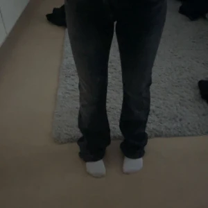 Svarta raka jeans med dubbla knappar - Säljer ett par svarta jeans med raka ben och dubbla knappar i midjan. Jeansen har klassiska fickor både fram och bak och är tillverkade i ett jeansmaterial. Perfekta för dig som gillar en enkel och stilren look.