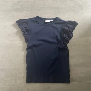 T-shirt från Gina Tricot  - Blå T-Shirt från Gina Tricot med volang på ärmarna, storlek 158/164.