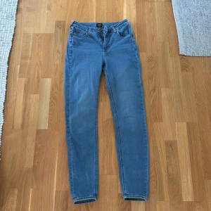 Lee Scarlett High ljusblå skinny jeans - Ljusblå skinny jeans från Lee, modell Scarlett High med hög midja. Klassisk femficksdesign, dragkedjegylf och Lee-logga bak. Jeansen är tillverkade i stretchig bomullsdenim för en tight och bekväm passform. Org pris 1200