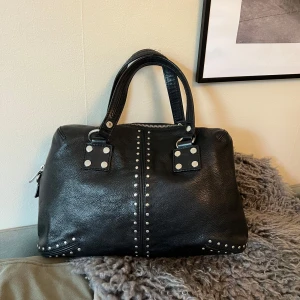 Michael kors handväska  - Astor Large Studded Leather Tote Bag Material:  100% Leather Silver-tonande detaljer Storlek: 37 X 25 X 11.5 cm Insidan har 2 öppna fickor samt 1 med kedja.          Skick: knappt använd 