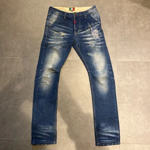 Blå jeans från Adrian Hammond, stl 30 - Snygga blå jeans från Adrian Hammond med slitna detaljer och ljusa partier framtill och baktill. Klassisk fyrficksmodell. Ett par klassiska raka/ slim jeans med bra passform. 